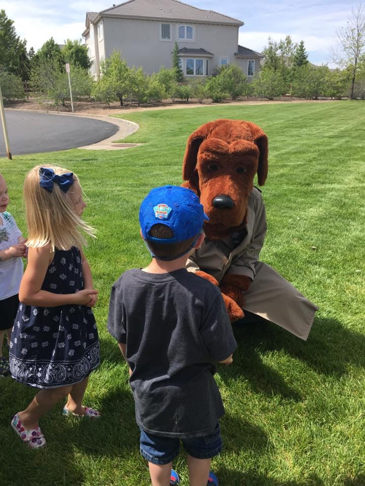 Children interacting with a person in a dog costume