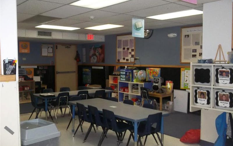 An empty classroom with tables and chairs