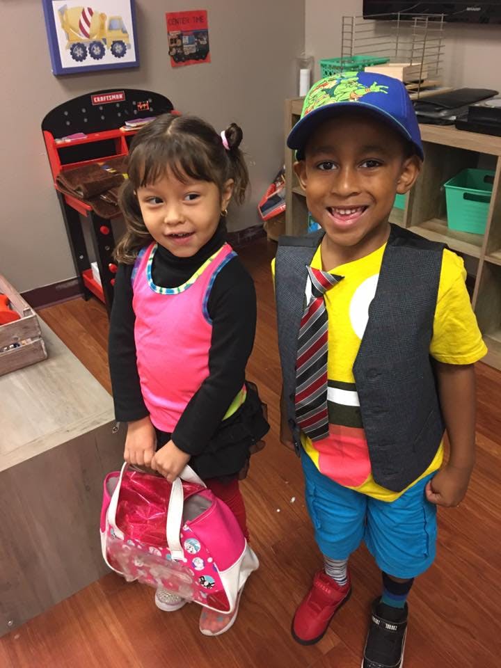 Two children standing, one holding a bag