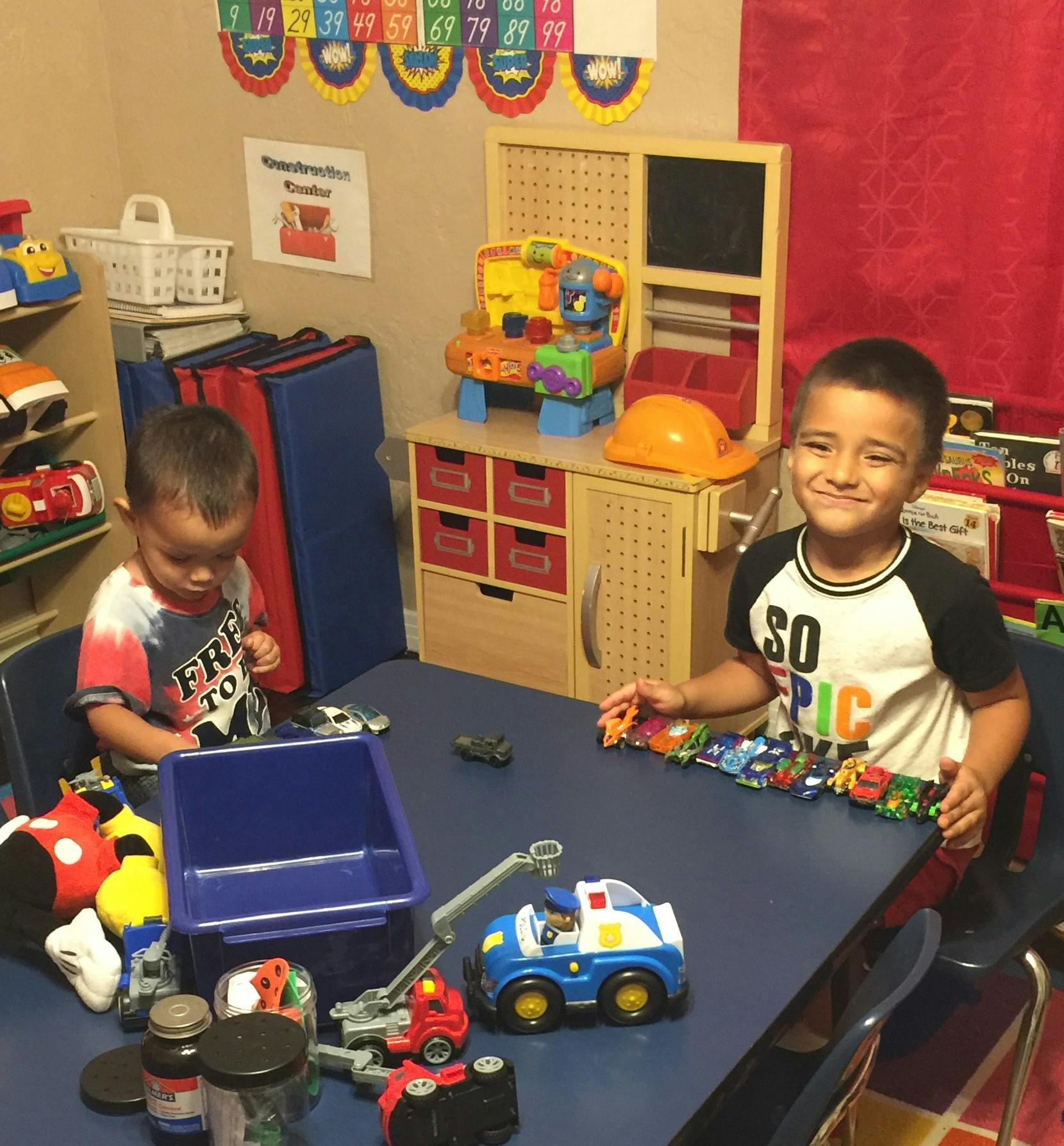 Two children playing with toys at a table