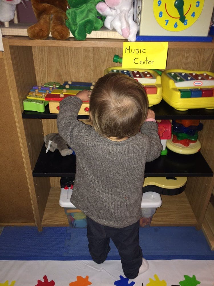 Child playing with a toy xylophone at a music center
