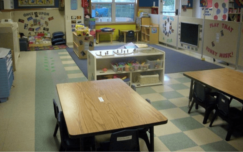 An empty colorful classroom with small tables and chairs