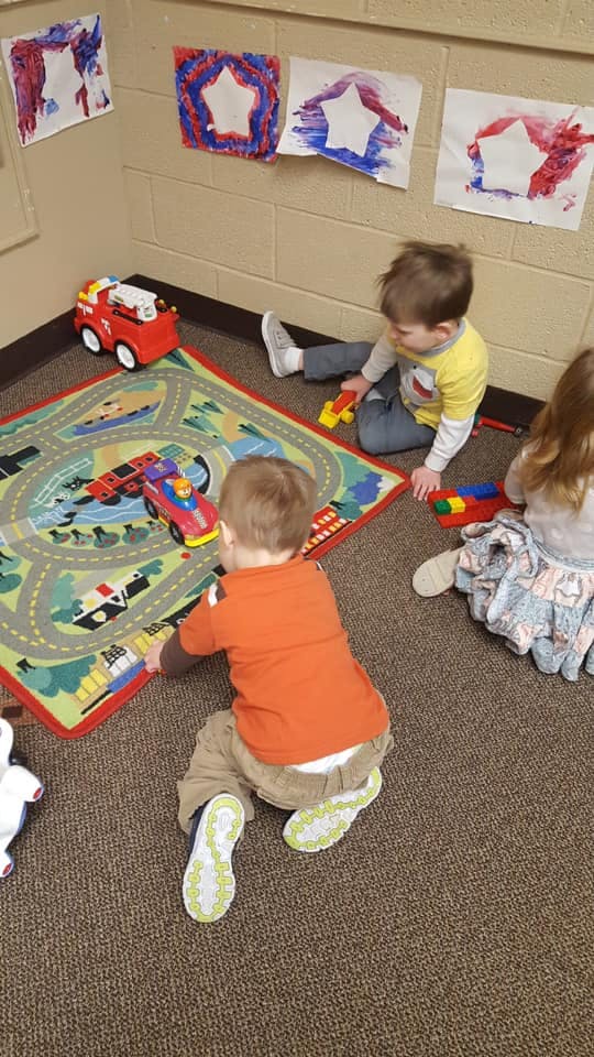 Children playing with toys on a rug