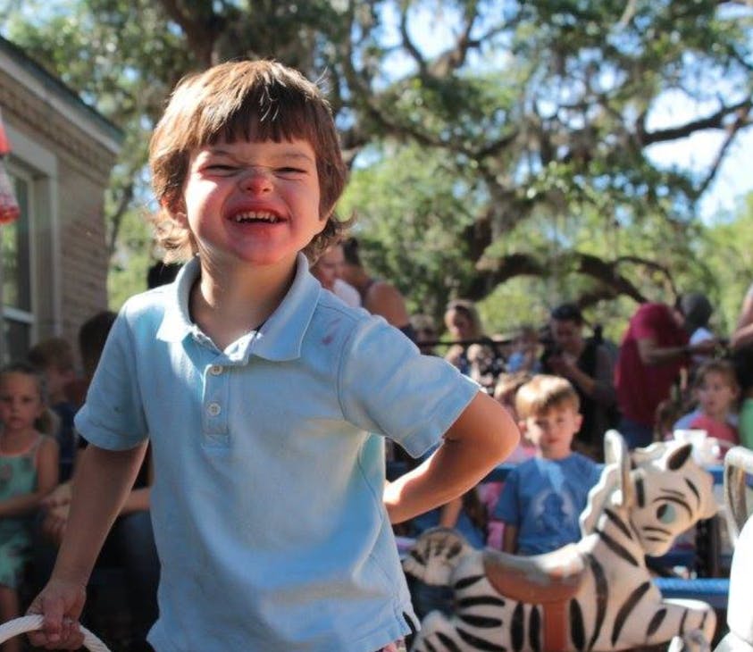 Child in a light blue shirt smiling