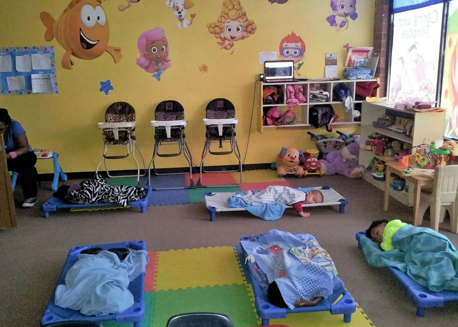 Children sleeping on cots in a daycare room