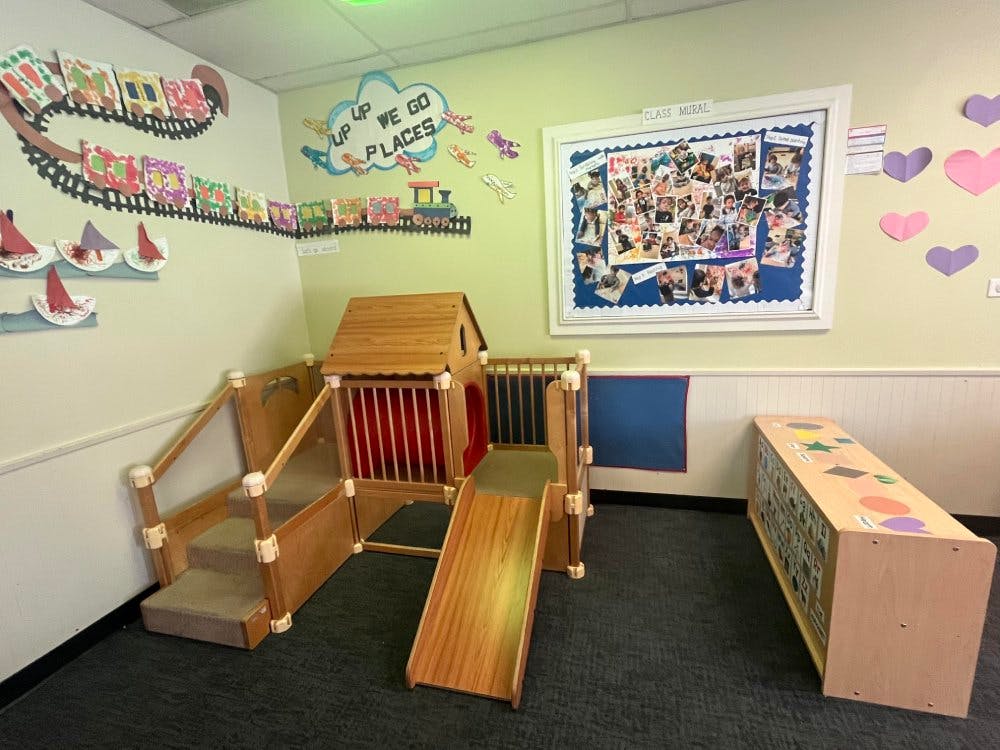 Indoor play structure with a slide, stairs, and a small house in-ground tunnel