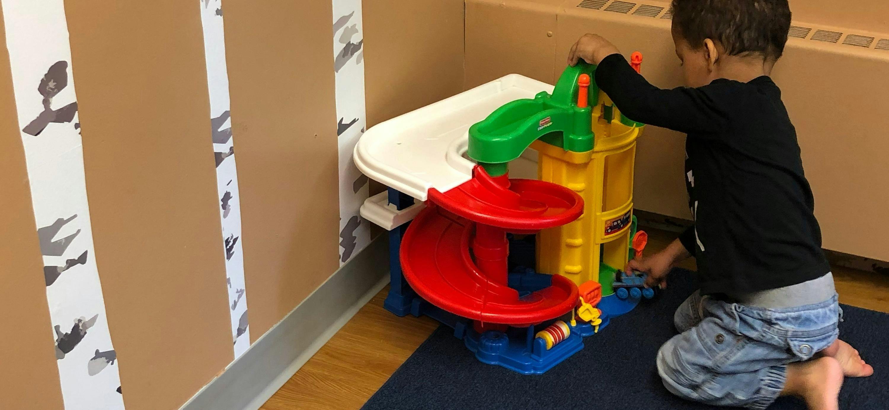 Child playing with a toy car ramp