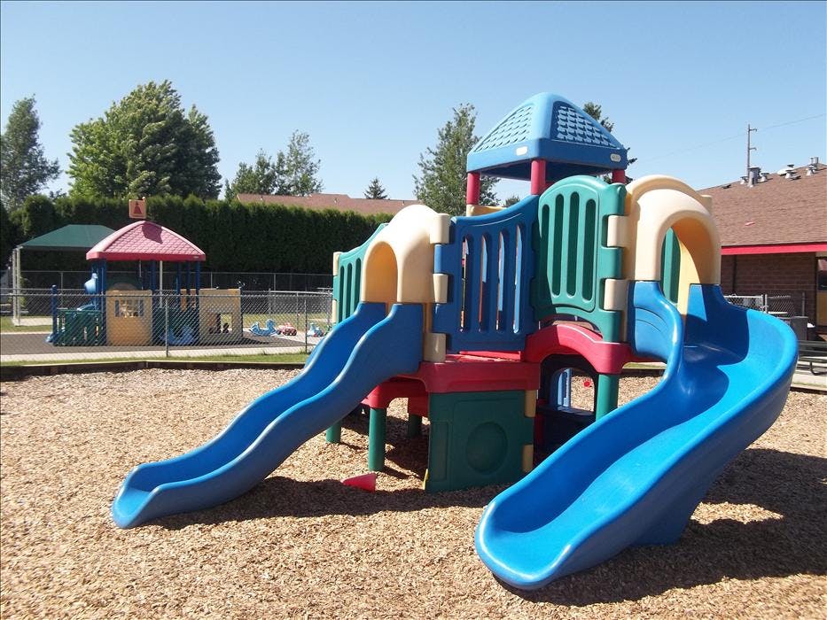 Children's playground with slides and a play structure on wood chips
