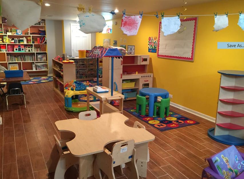 Playroom with small tables and chairs, shelves, and yellow walls