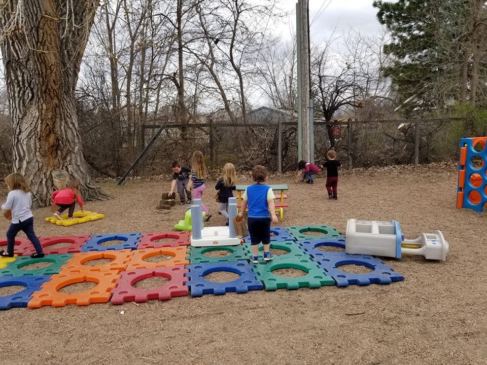 Children playing on colorful mats outdoors
