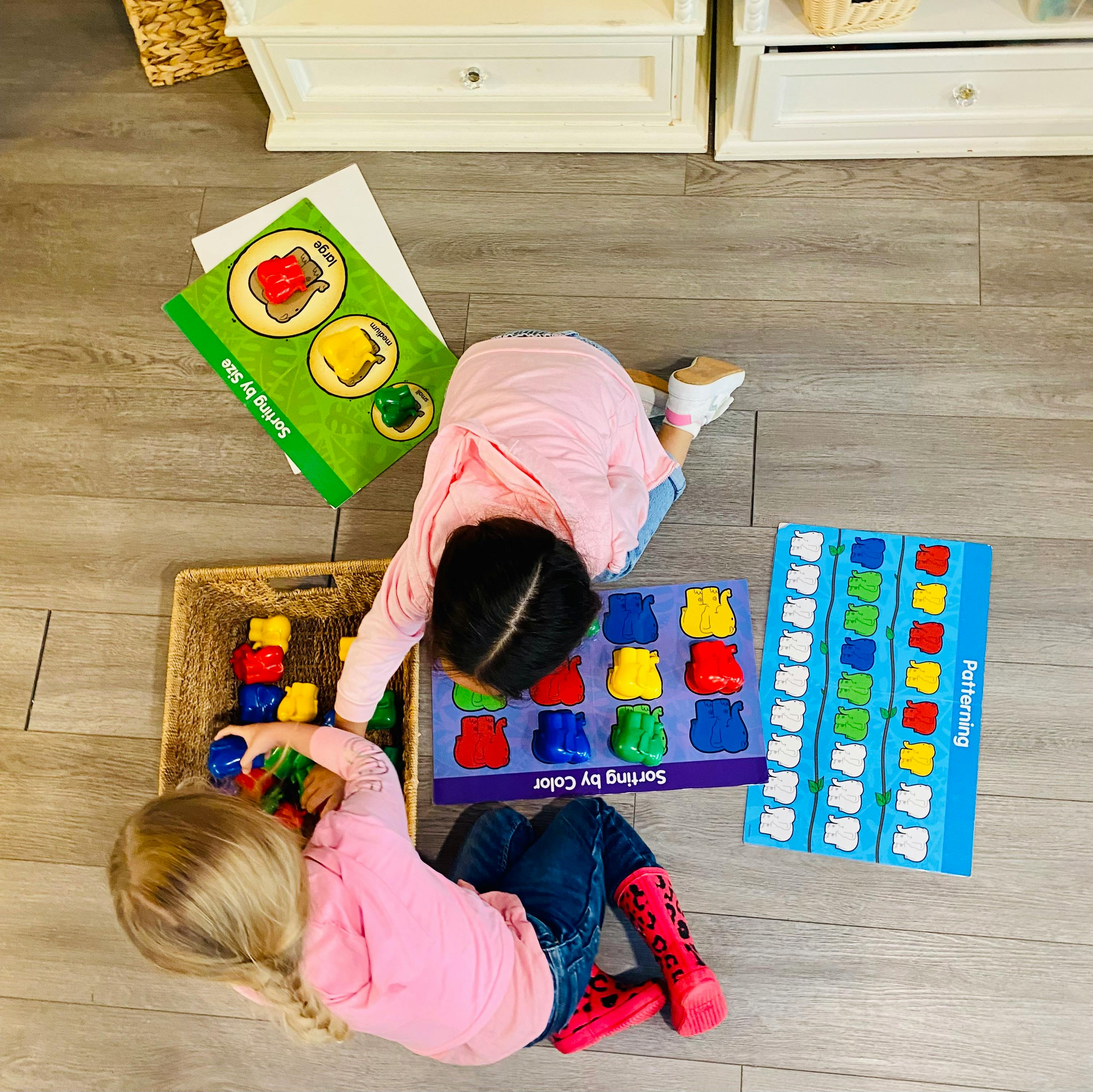 Two children playing with sorting toys on the floor