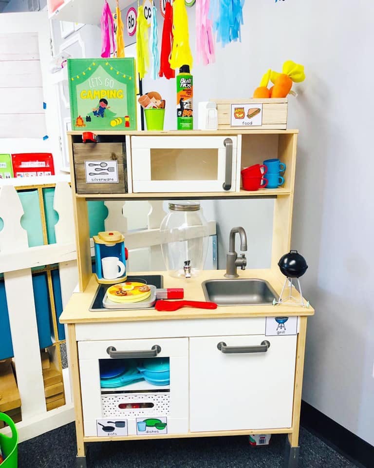Child's play kitchen with toy food and utensils