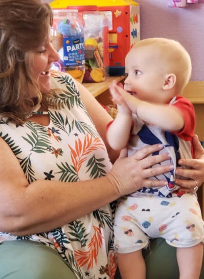 Person holding a child who is clapping hands