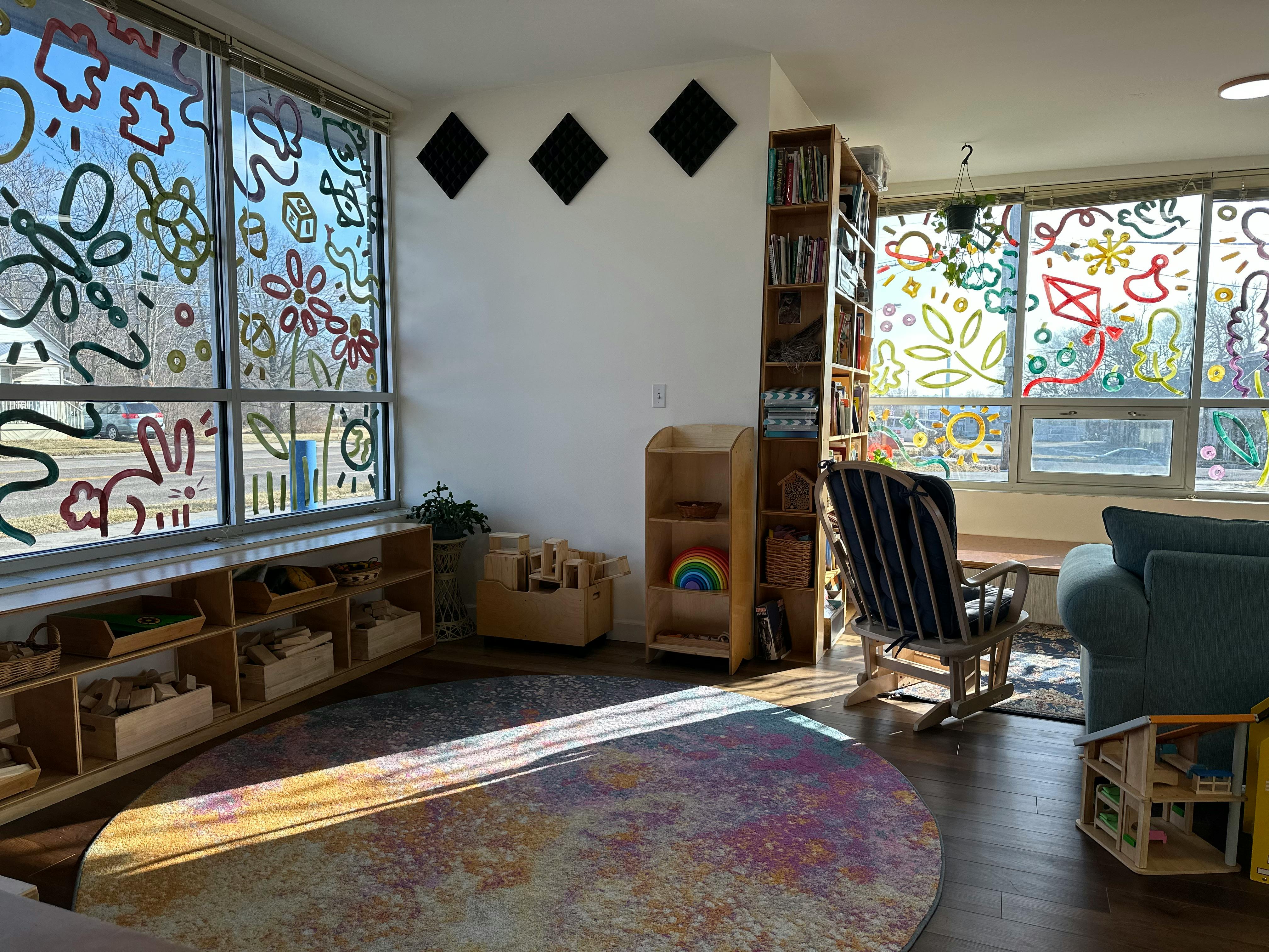 Room with large windows decorated with colorful drawings