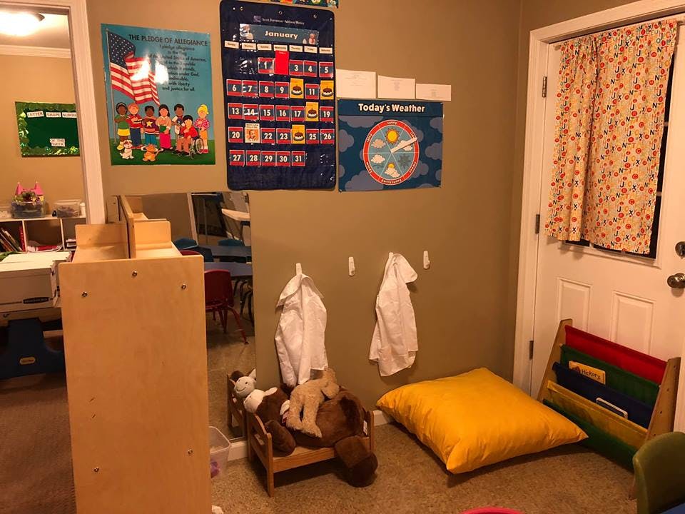 Classroom with educational posters, small furniture, and a door