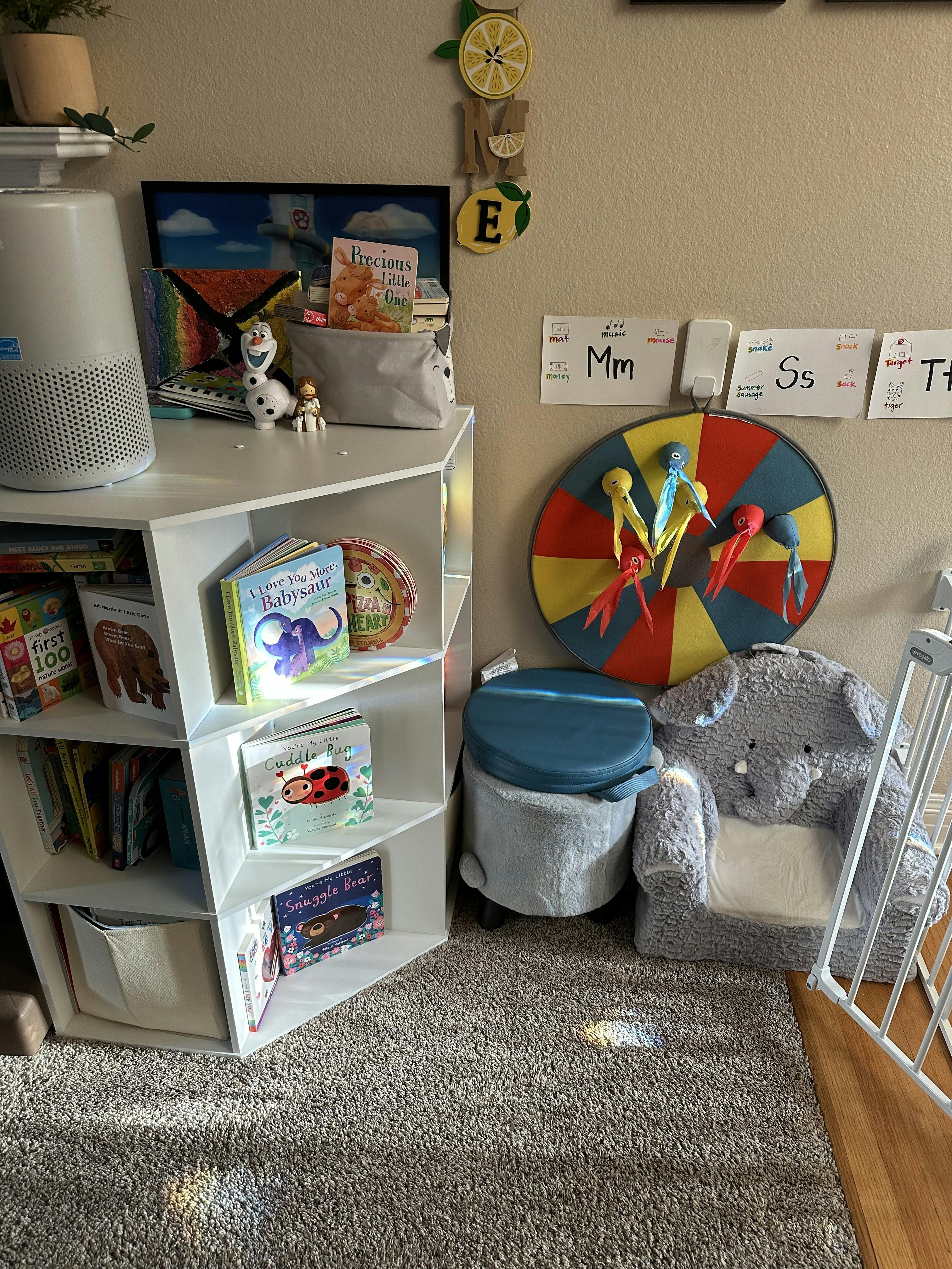 Children's room with a bookshelf, an elephant chair, and alphabet charts on the wall