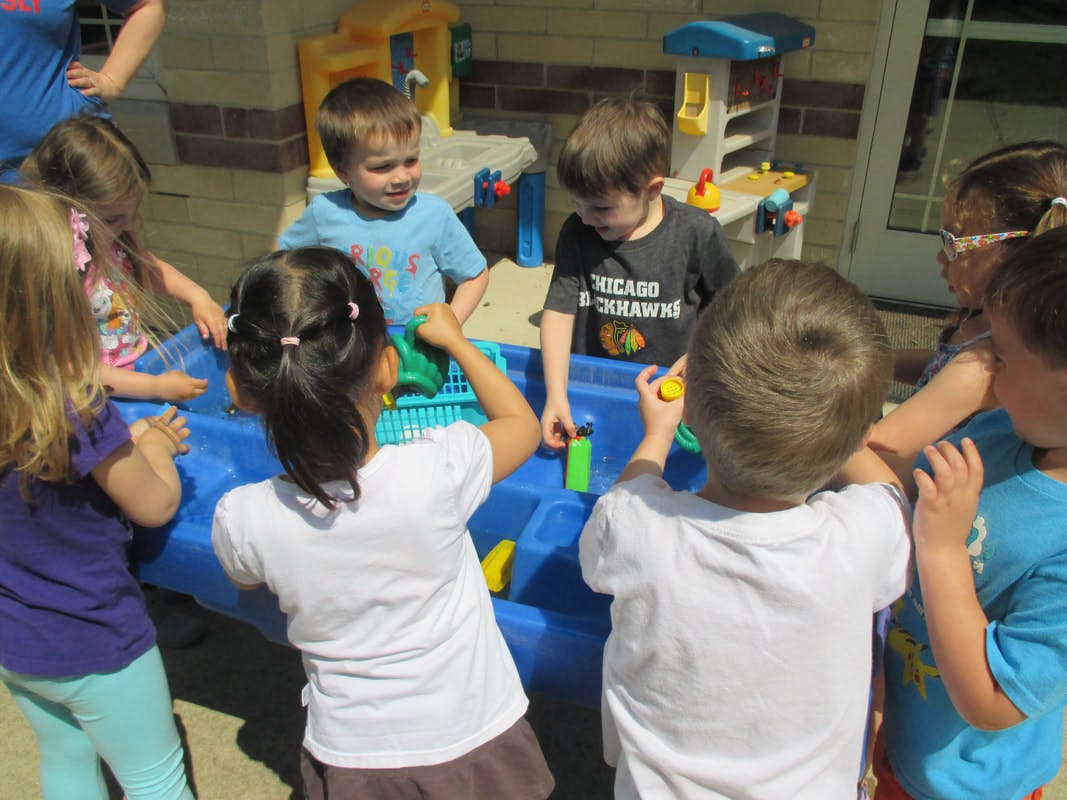 Children playing with a water table outdoors