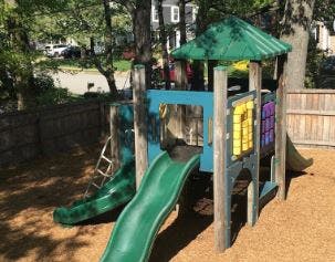 Playground structure with green slides and a green roof