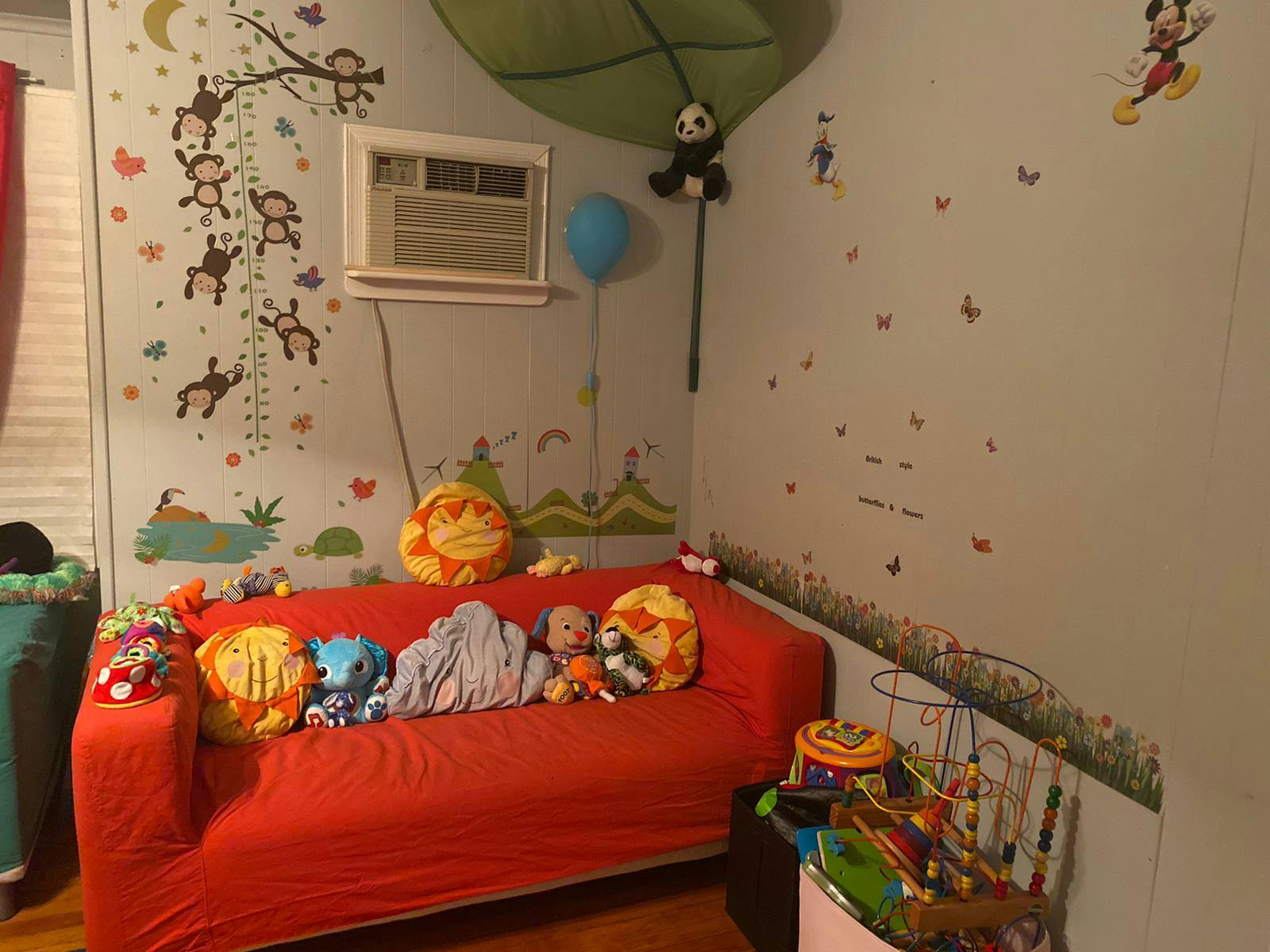 Child's room with a red couch and wall decals