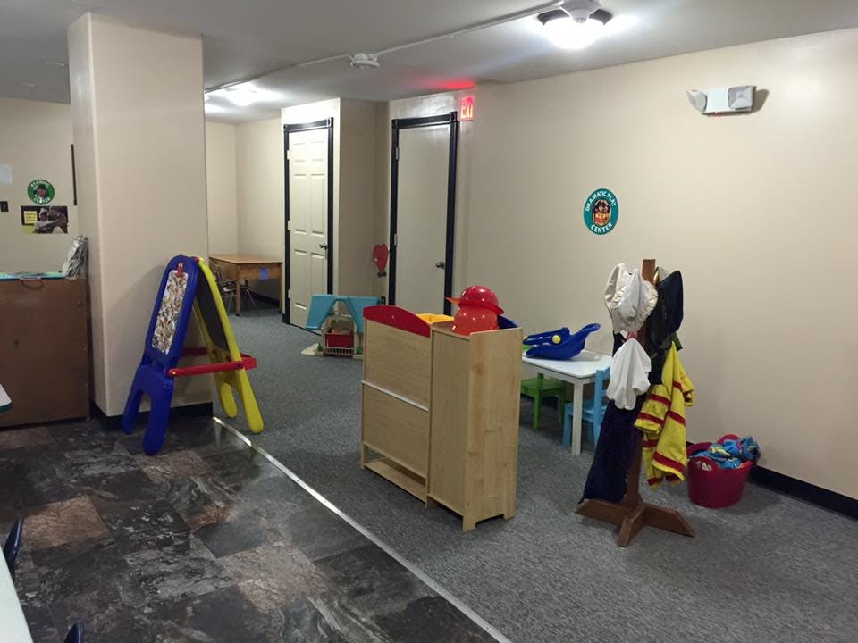 Children's play area with an easel, wooden cabinet, and coat rack