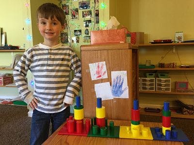 Child standing next to colorful stacking toys