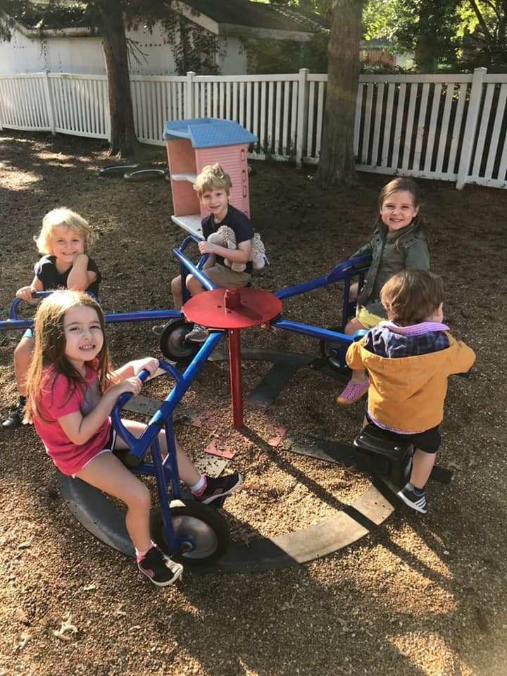 Four children on a playground merry-go-round