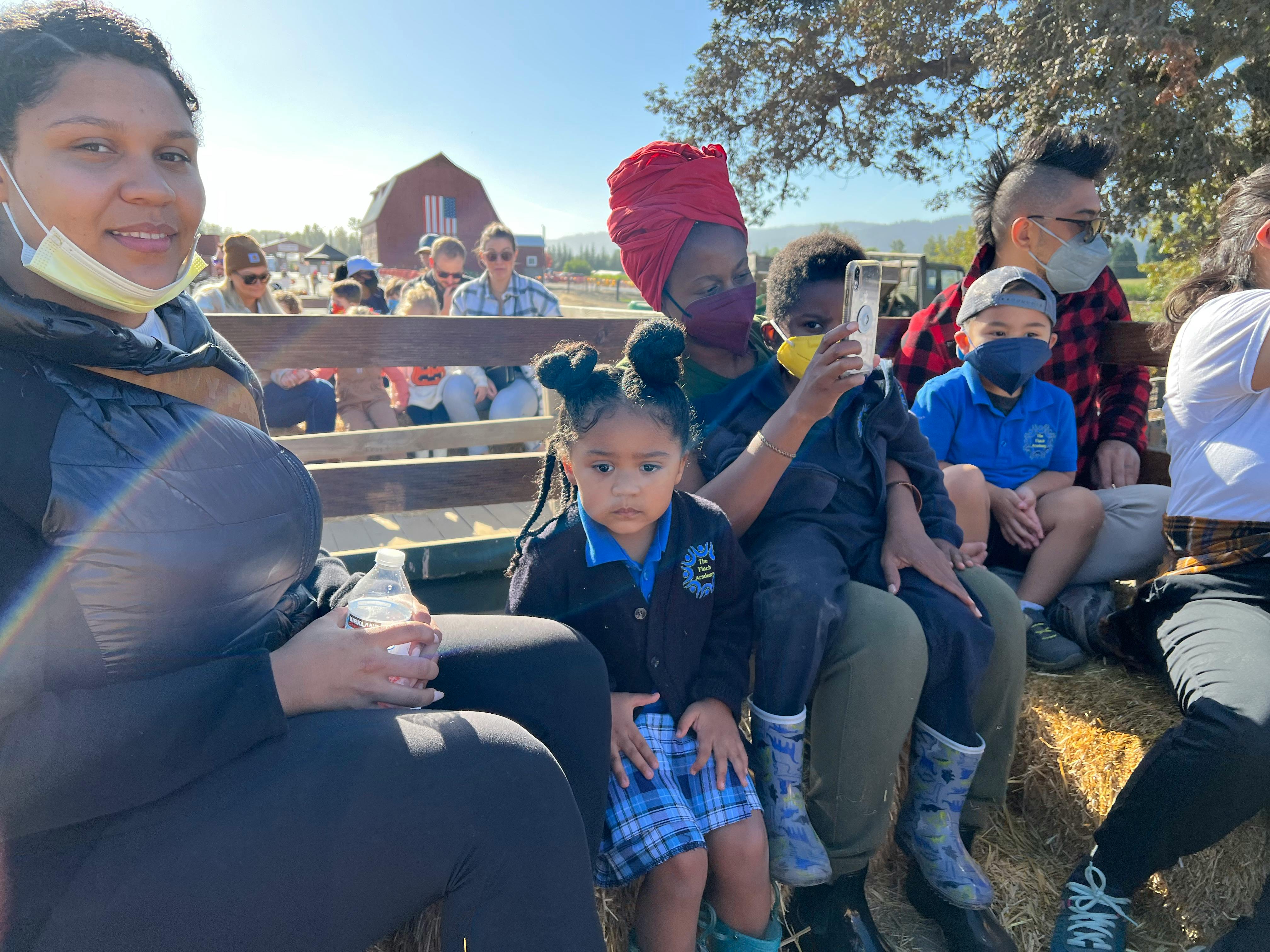 People and children sitting on a hayride