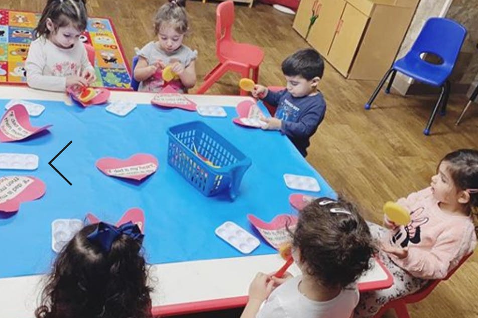 Children sitting around a table with craft supplies