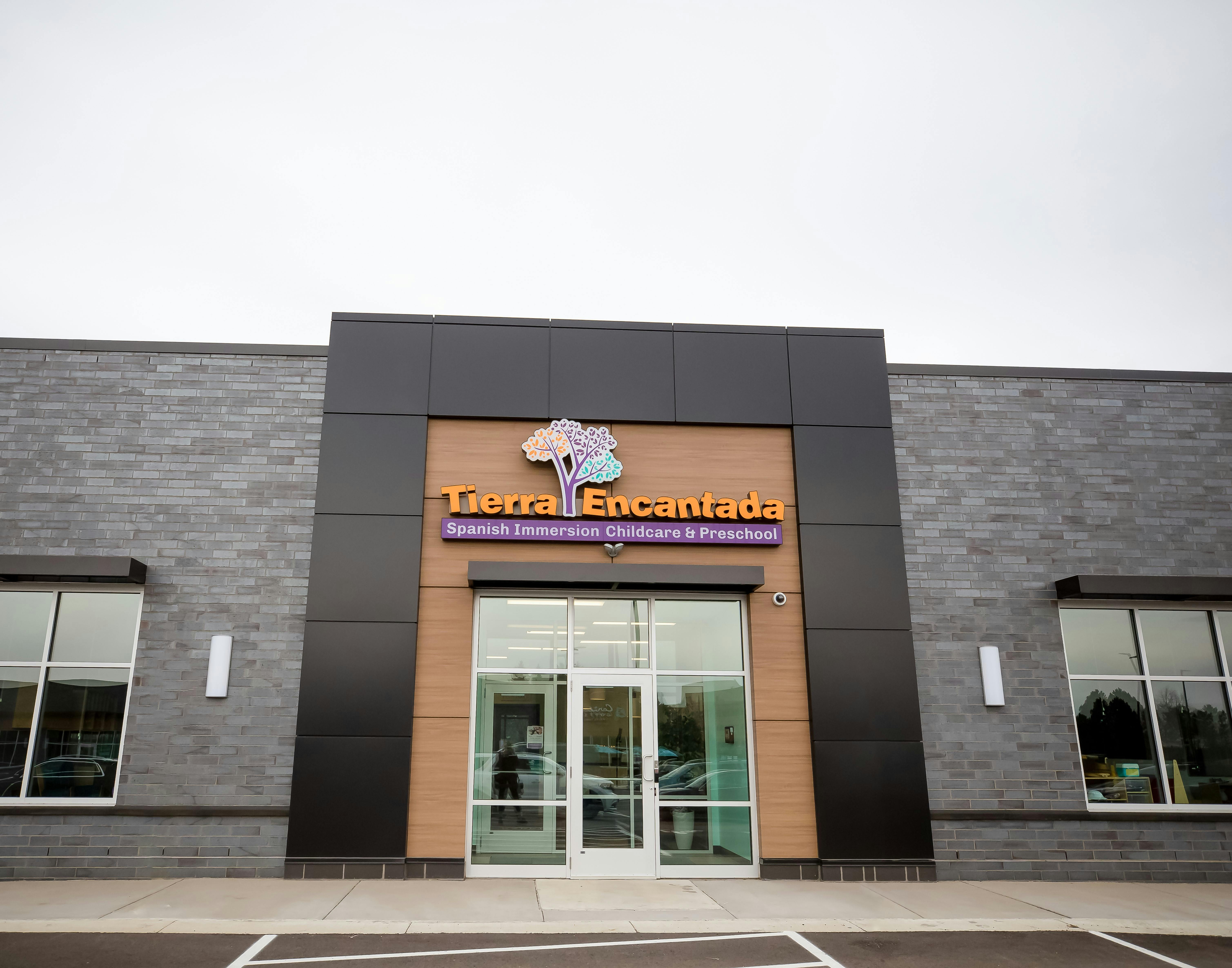 Building exterior with "Tierra Encantada" sign above glass doors