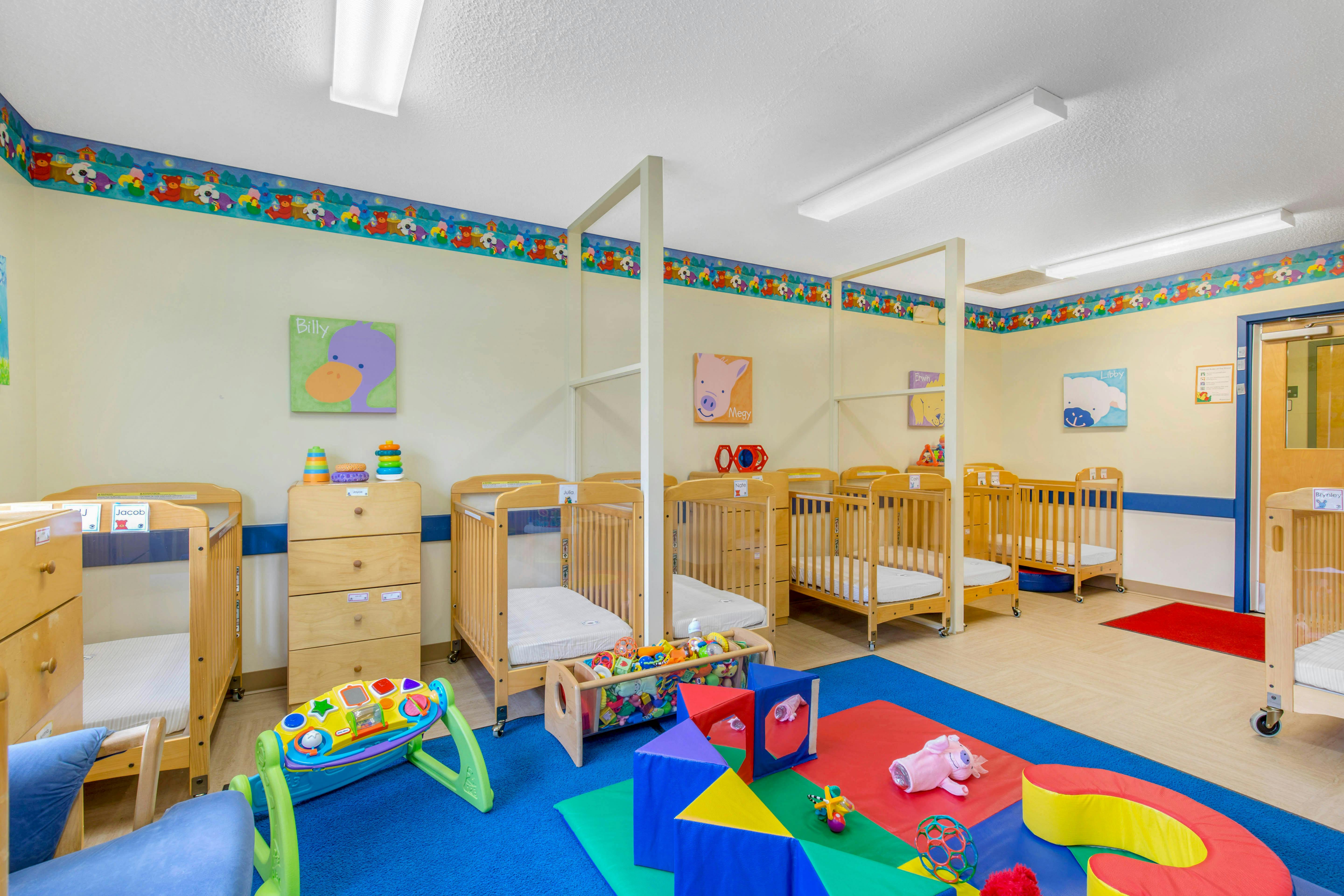 Cribs and colorful play mats in a daycare room