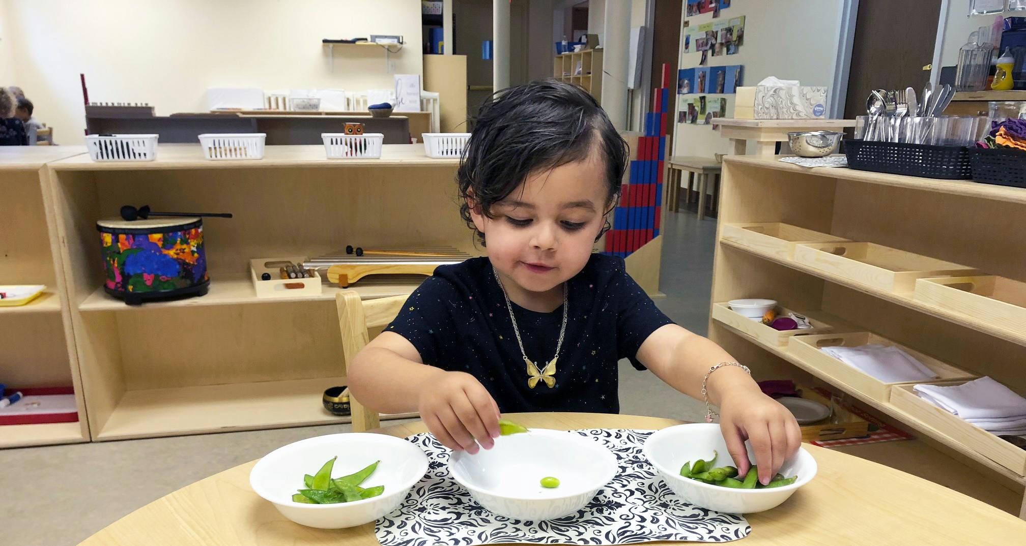 Child sorting green vegetables into bowls