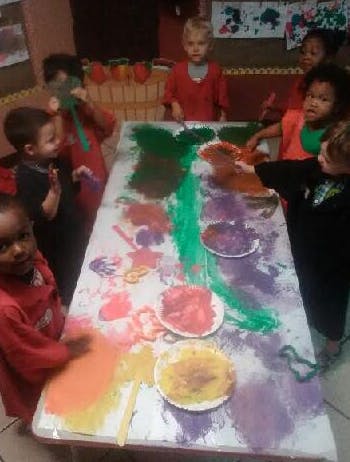 Children painting at a table in a classroom