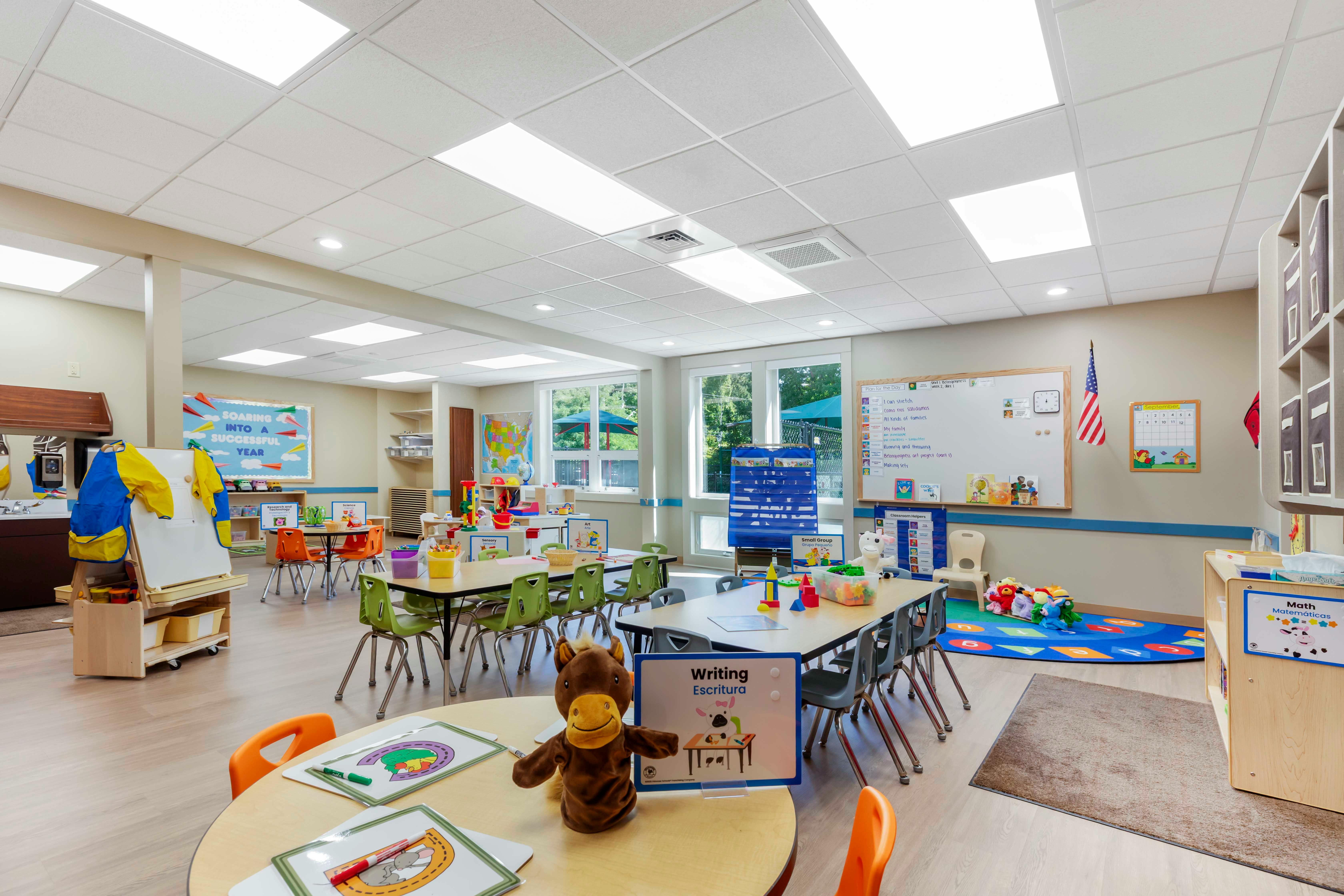 Classroom with child-sized tables and chairs, whiteboards, and learning materials