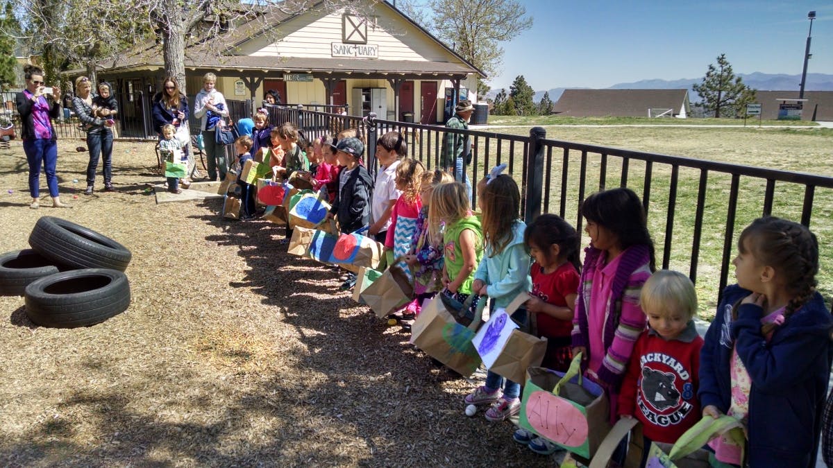 Children holding baskets in a line outdoors