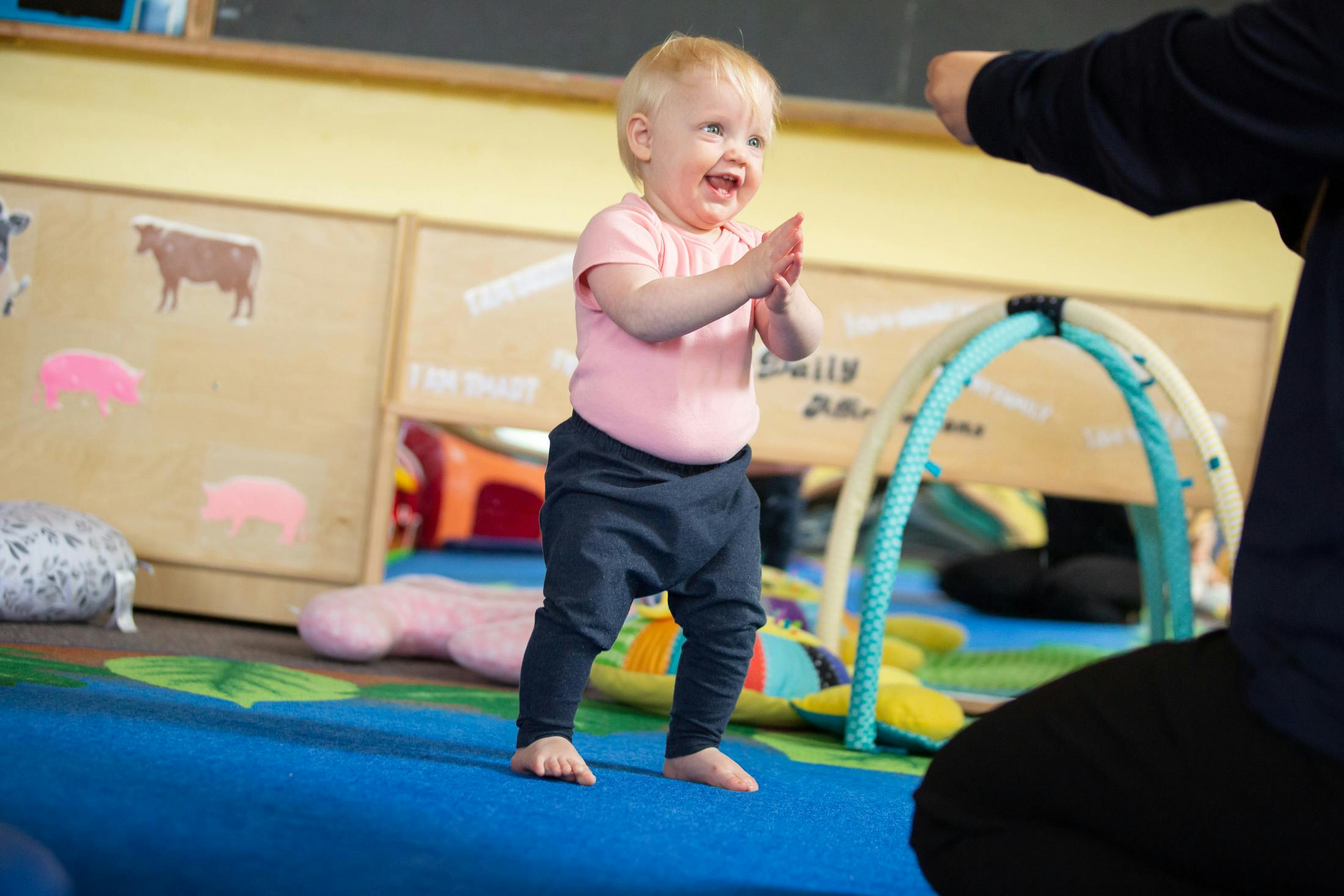 Child standing and clapping hands in a play area