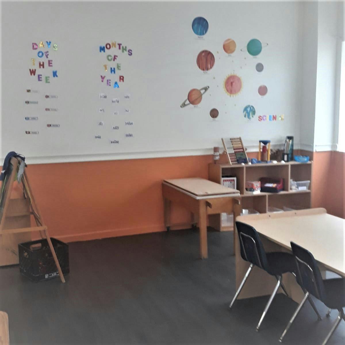 Classroom with educational wall decorations and small tables