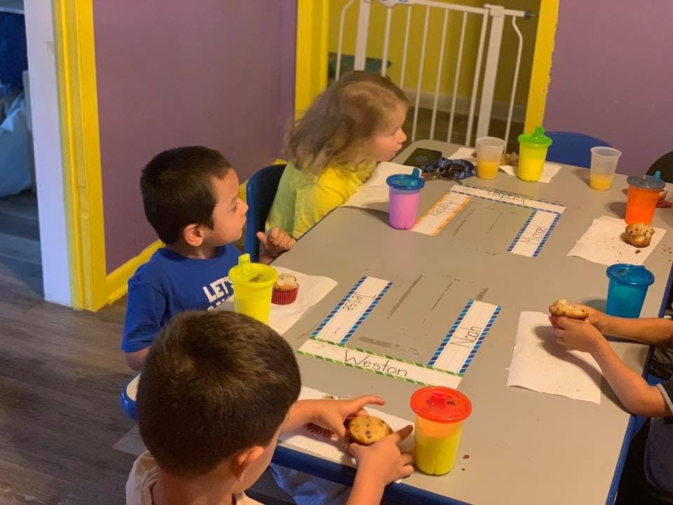 Children sitting at a table with drinks and snacks