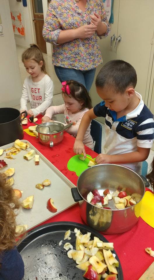 Children cutting apples in a classroom