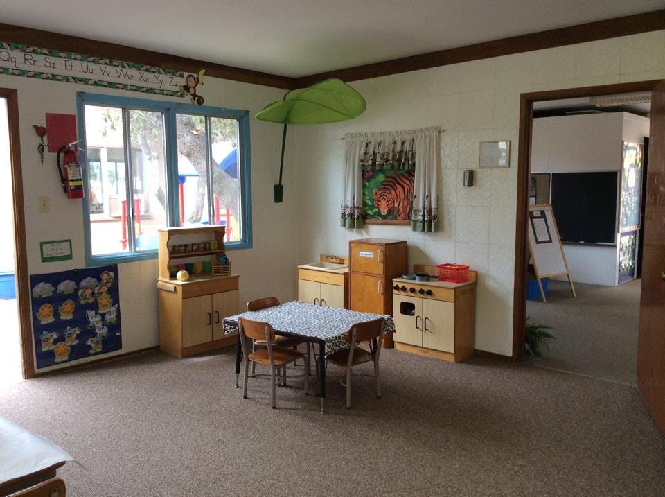 Playroom with small table and chairs, toy kitchen, and window