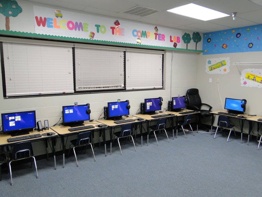Computer lab with multiple desks, chairs, and desktop computers