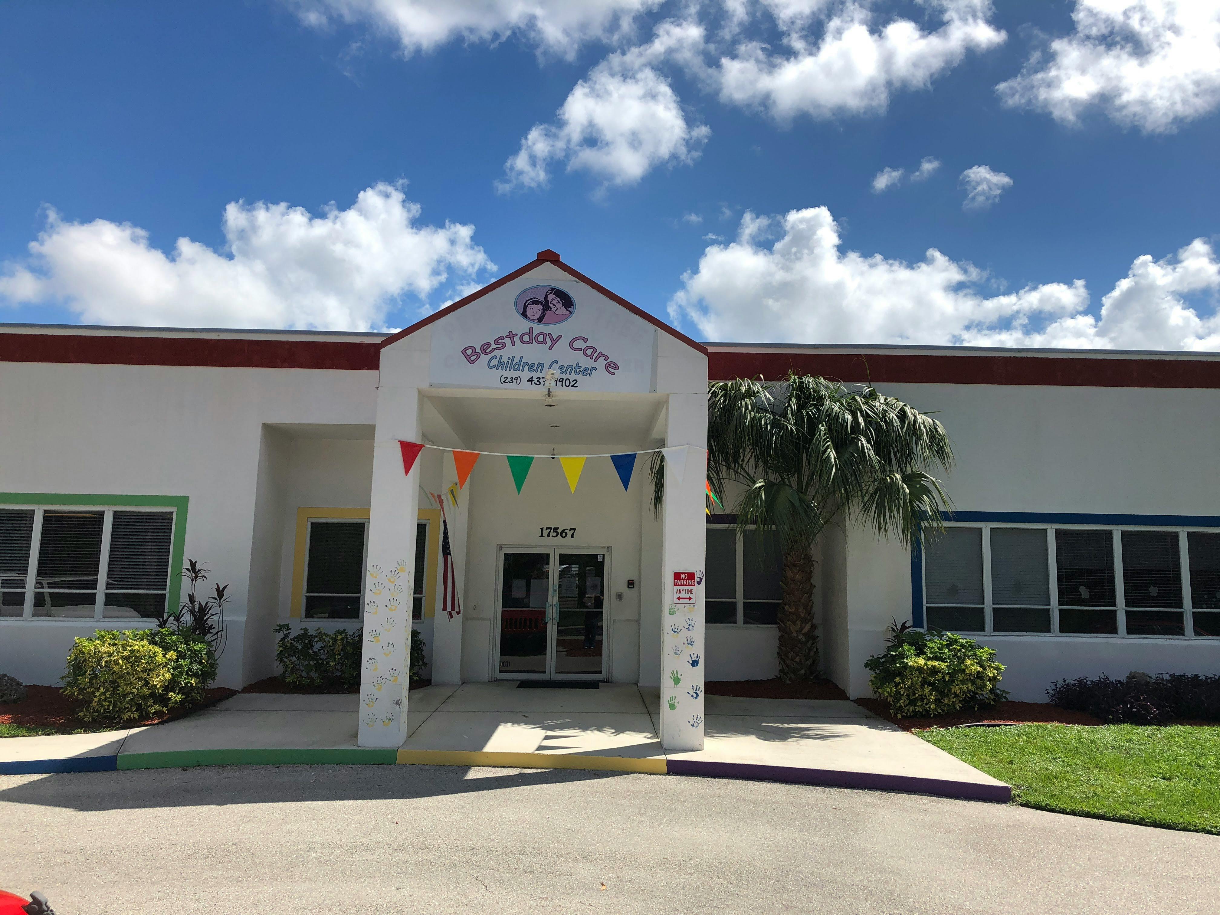 Building exterior with a covered entrance and colorful flags