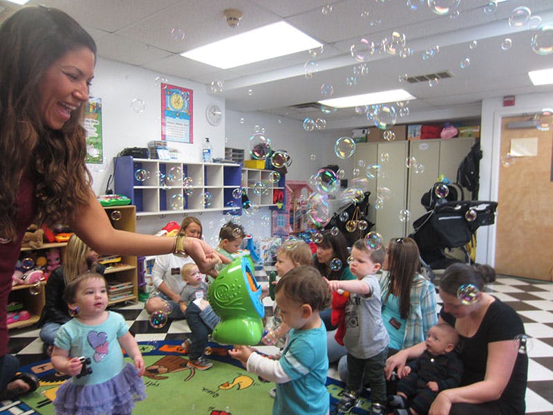 Person blowing bubbles for children in a classroom