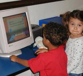 Two children looking at a computer screen