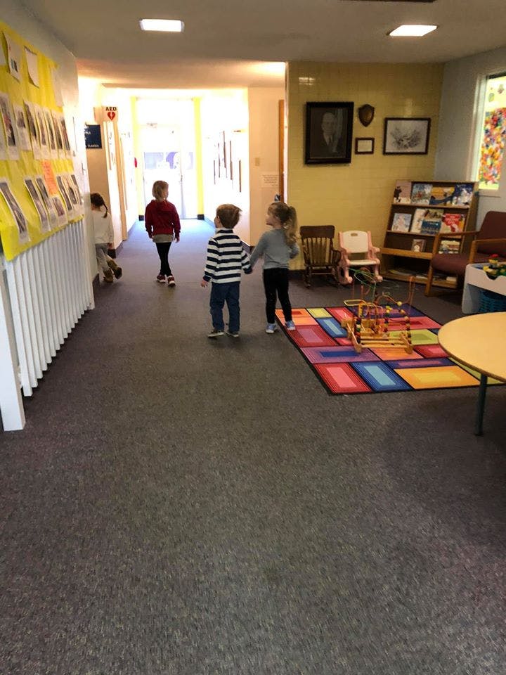 Four children walking in a hallway