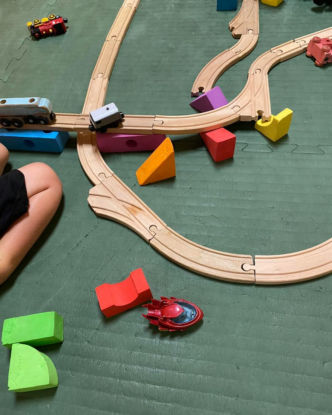 Wooden toy train tracks with colorful blocks and toy trains