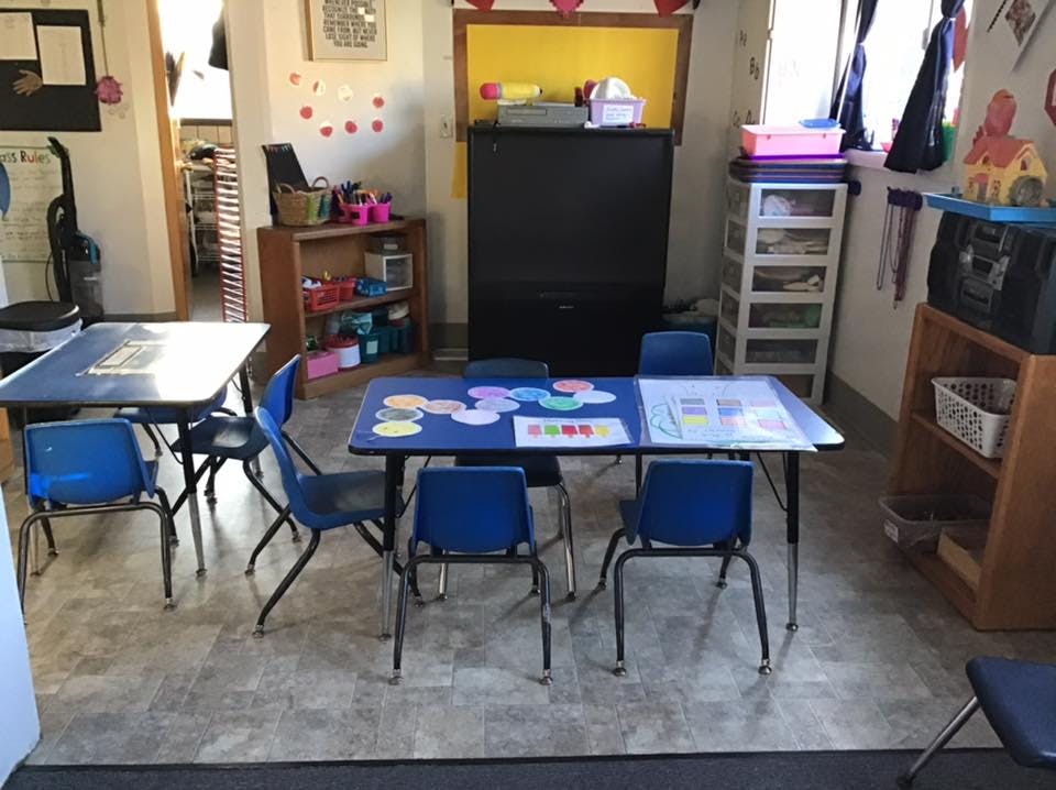 Classroom with small blue tables and chairs