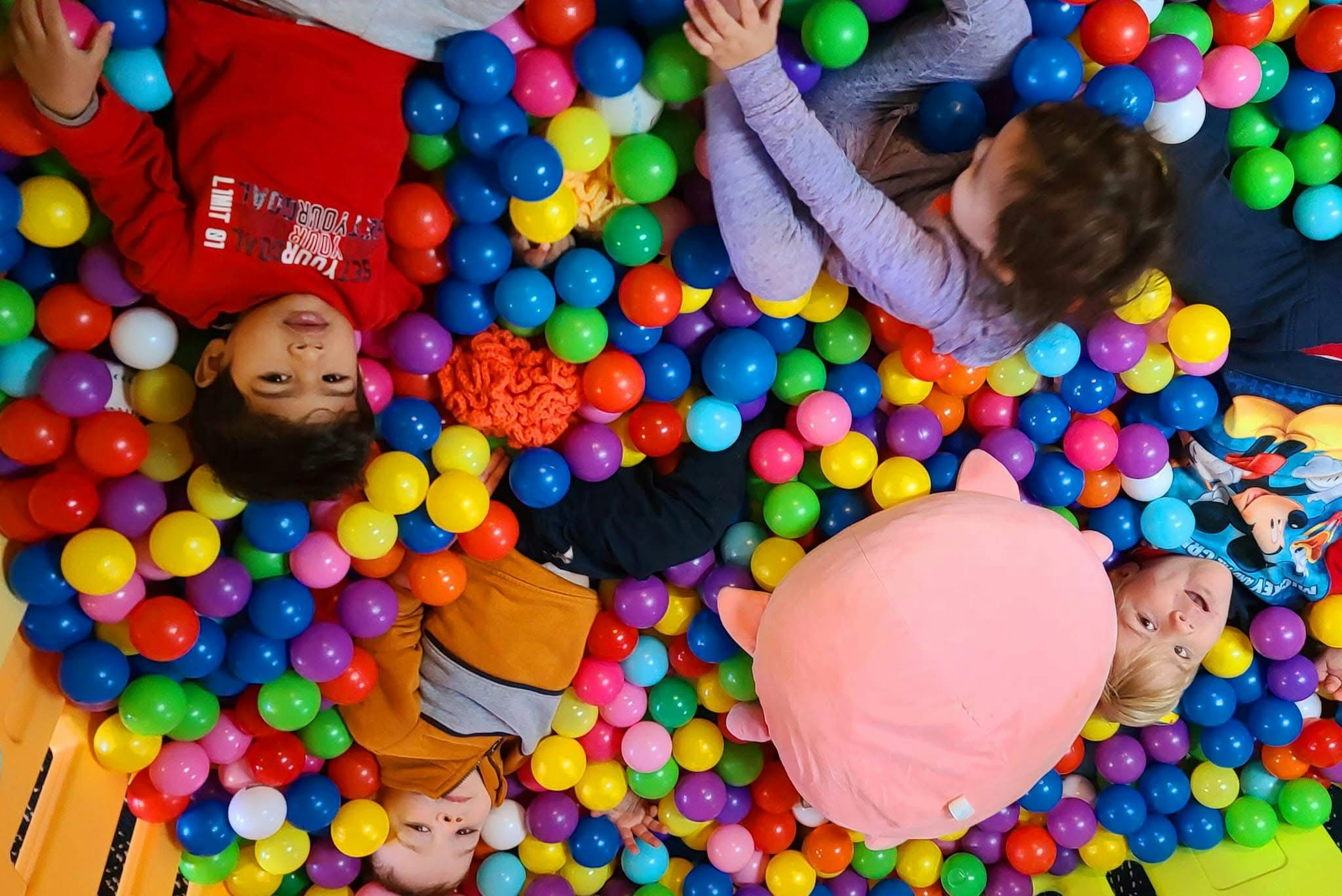 Children lying in a colorful ball pit