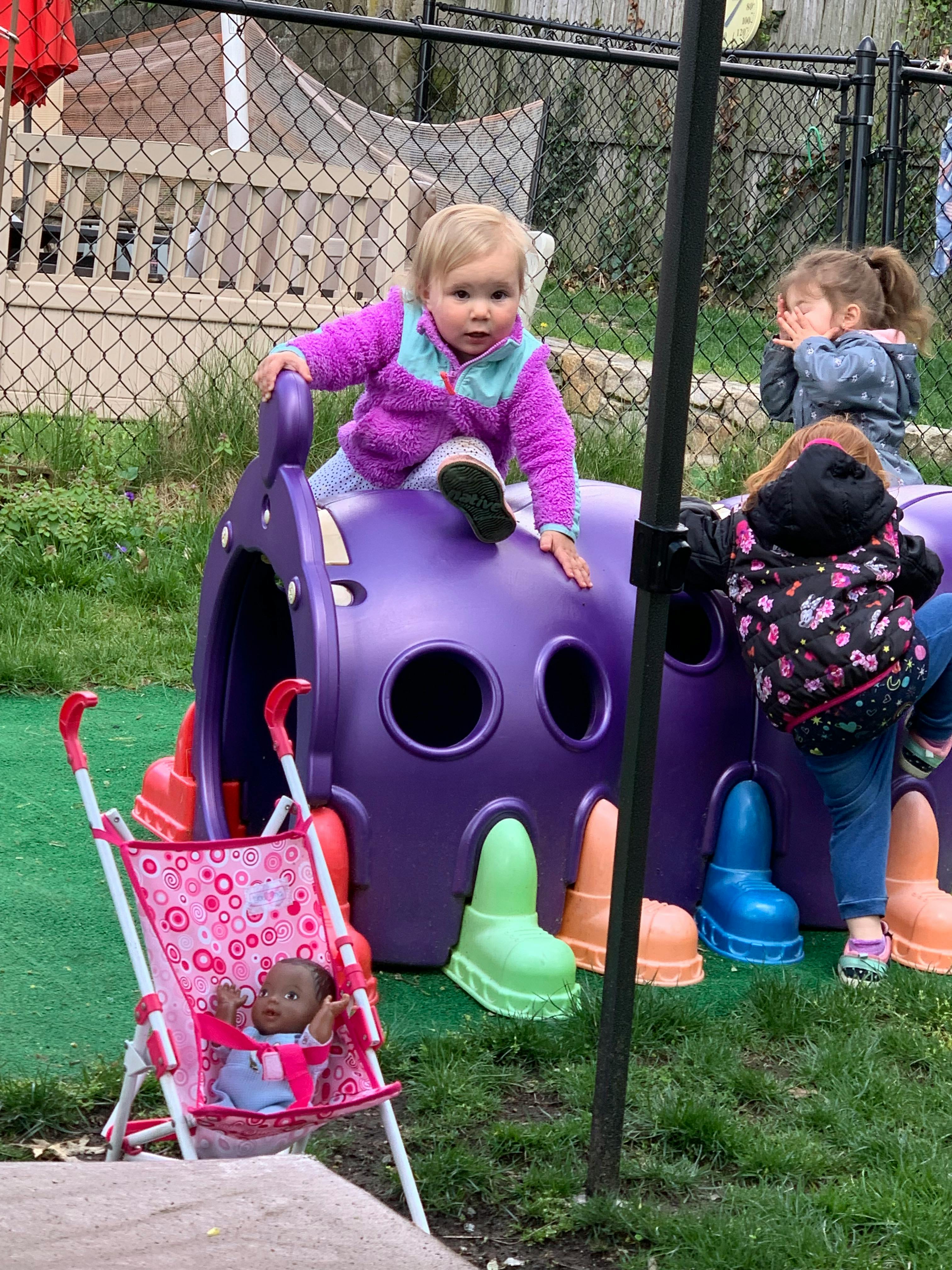 Child climbing on a purple play structure outdoors
