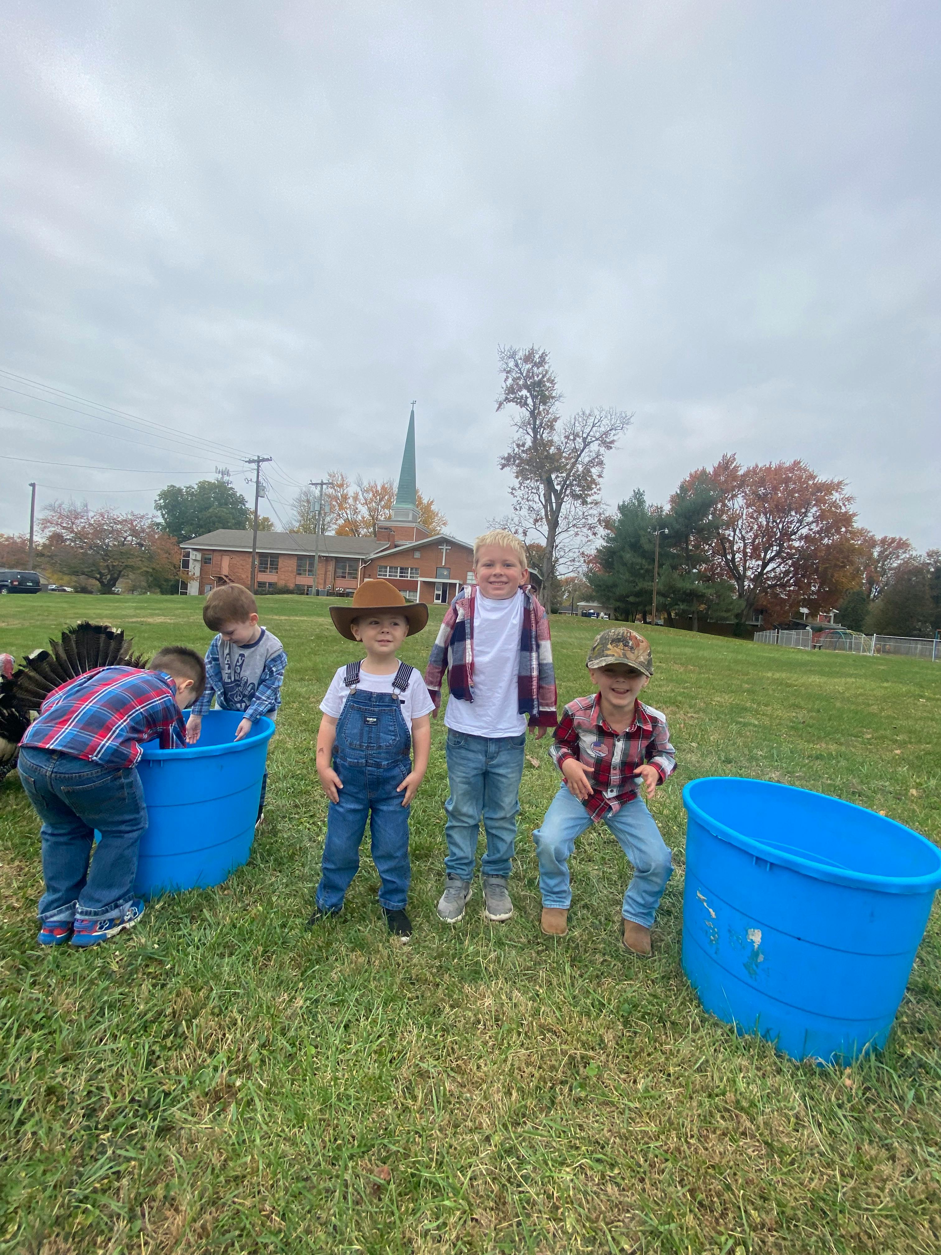 Children playing outdoors with blue tubs