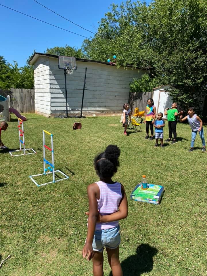 Children playing games in a grassy backyard